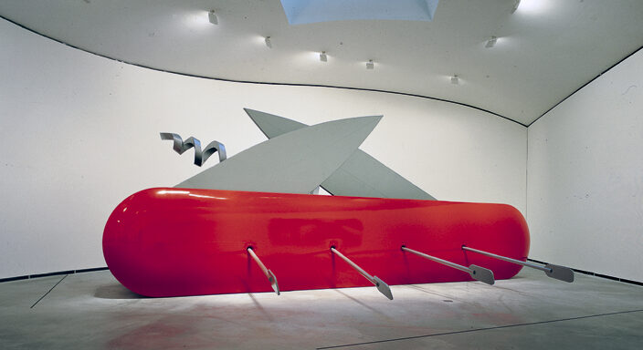 Escultura realizada por Claes Oldenburg que representa un barco con la forma de una navaja Suiza, en la que los elementos de la navaja constituyen las velas